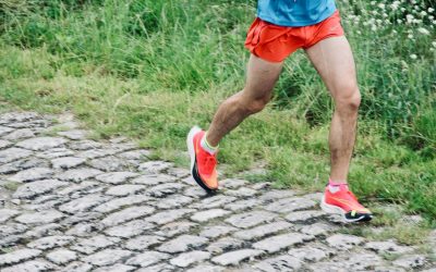 biegacz w sportowych butach podczas biegu po kamiennej nawierzchni